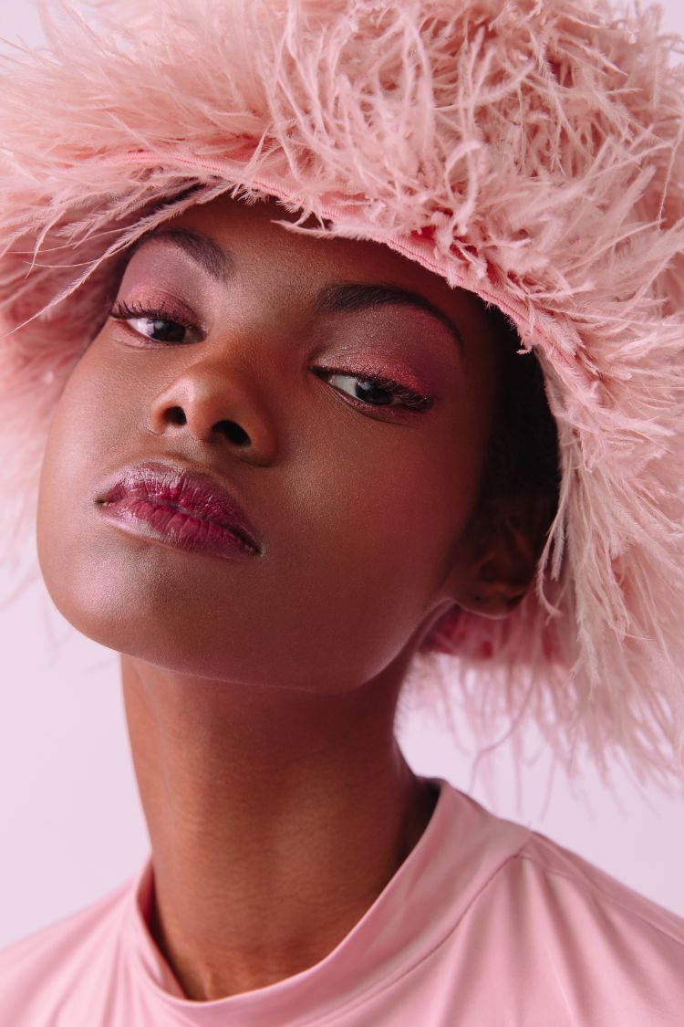 african american beauty model wearing a pink feather hat