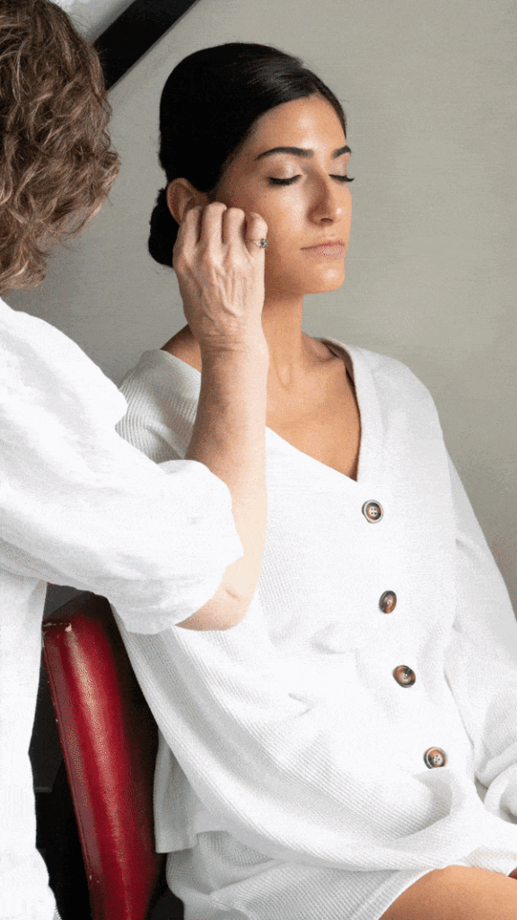 makeup artist Traci Fine applying foundation to a Bride's face on her wedding day