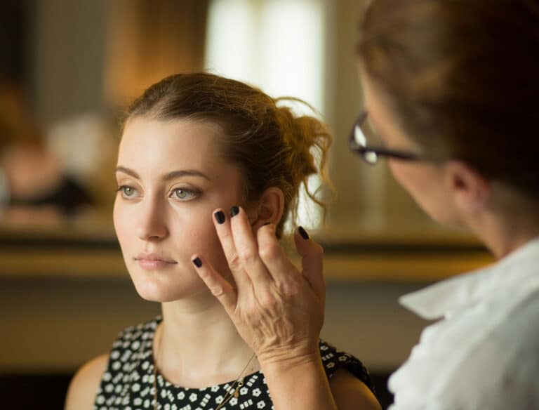 bride getting her makeup sone by a makeup artist