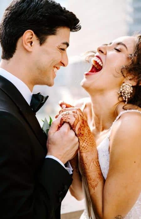 Bride and Groom holding hands laughing on their wedding day